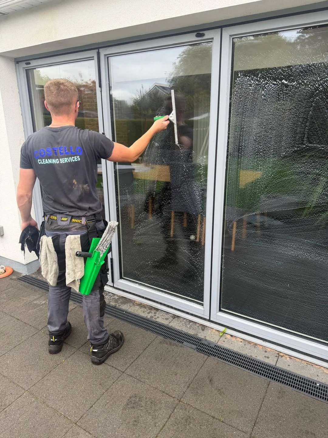 Adam Costello squeegeeing bifold glass doors
