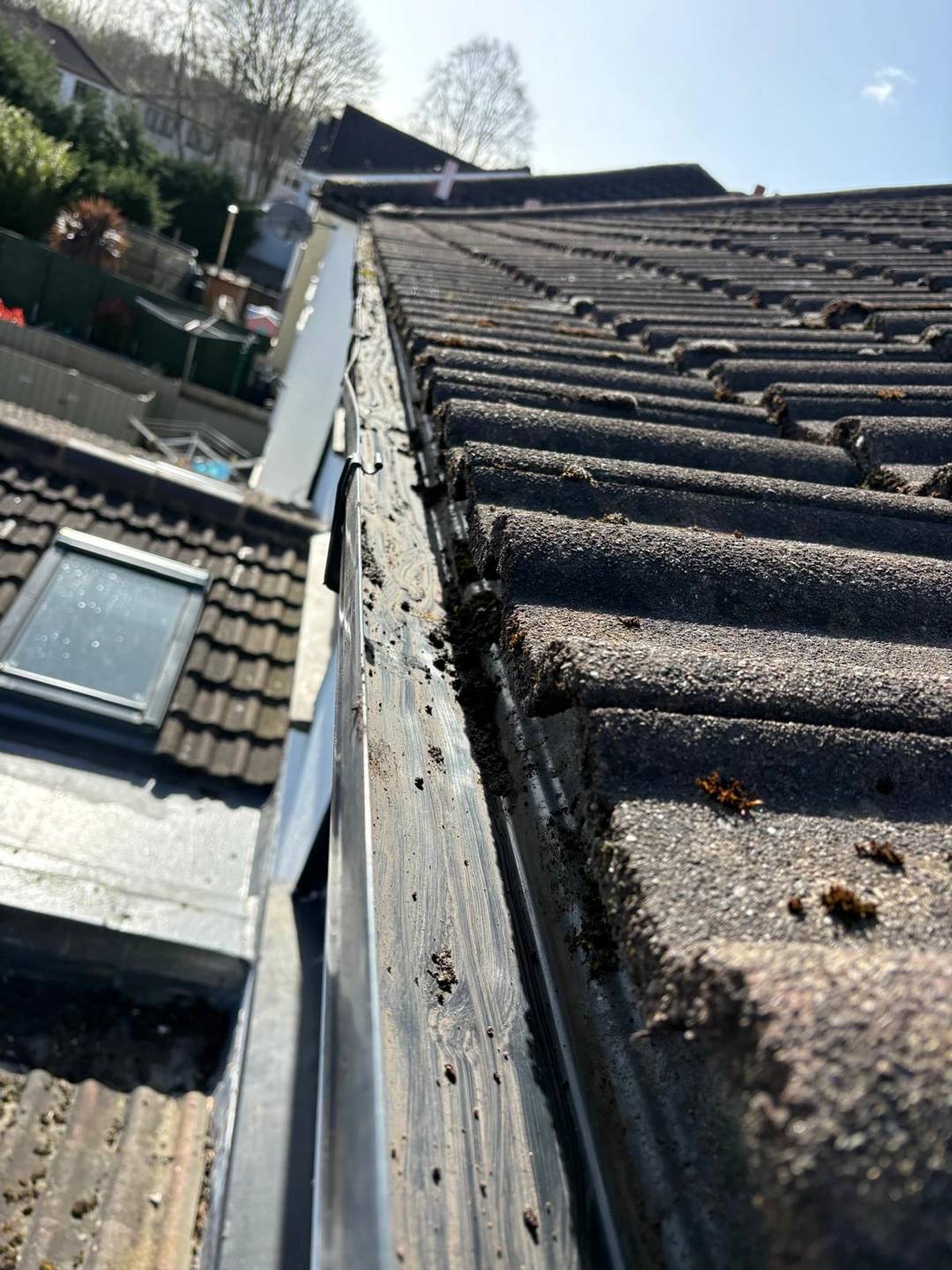 Gutter cleared out along a tiled roof